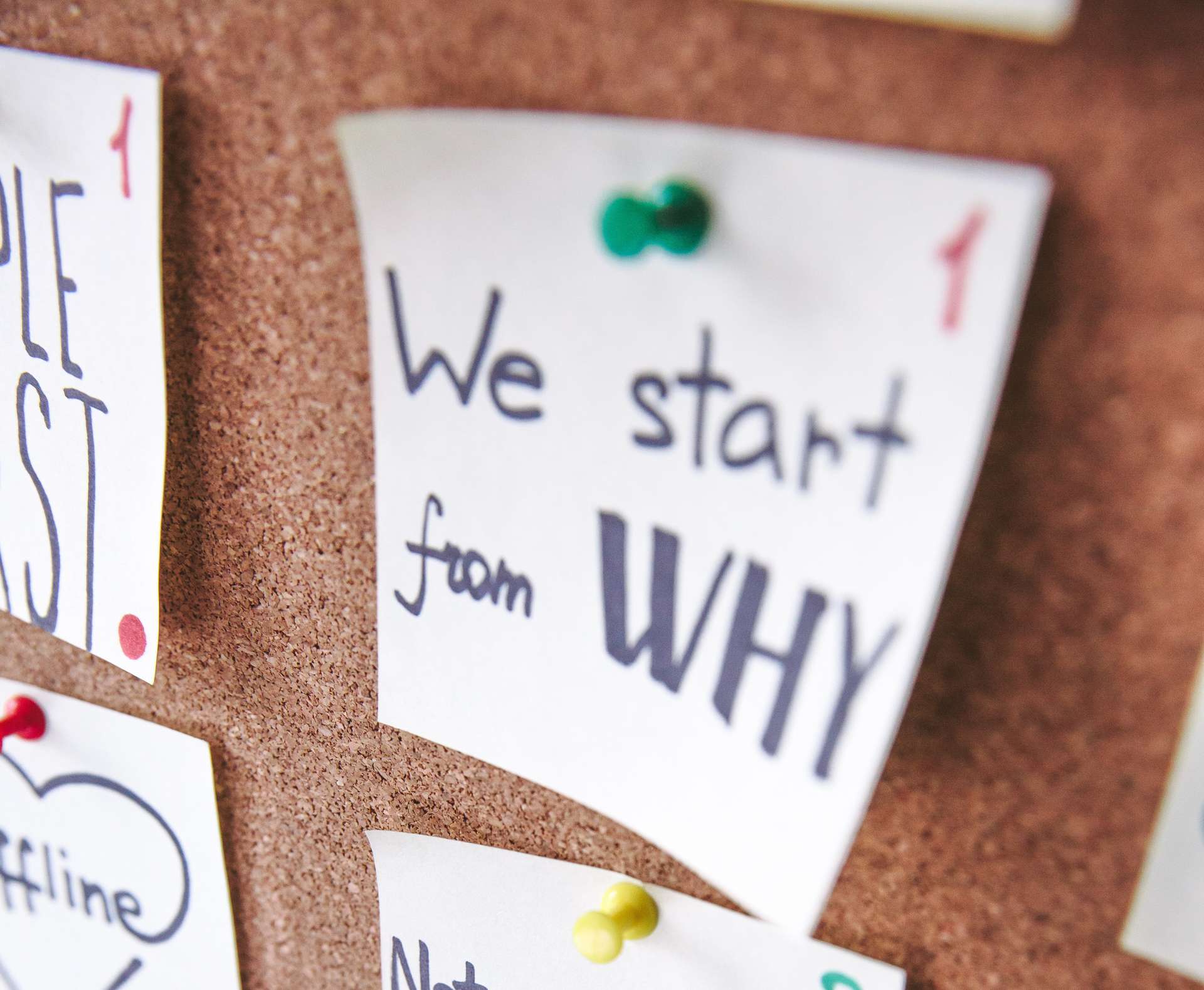 postit note on a corkboard with we start from why written on it