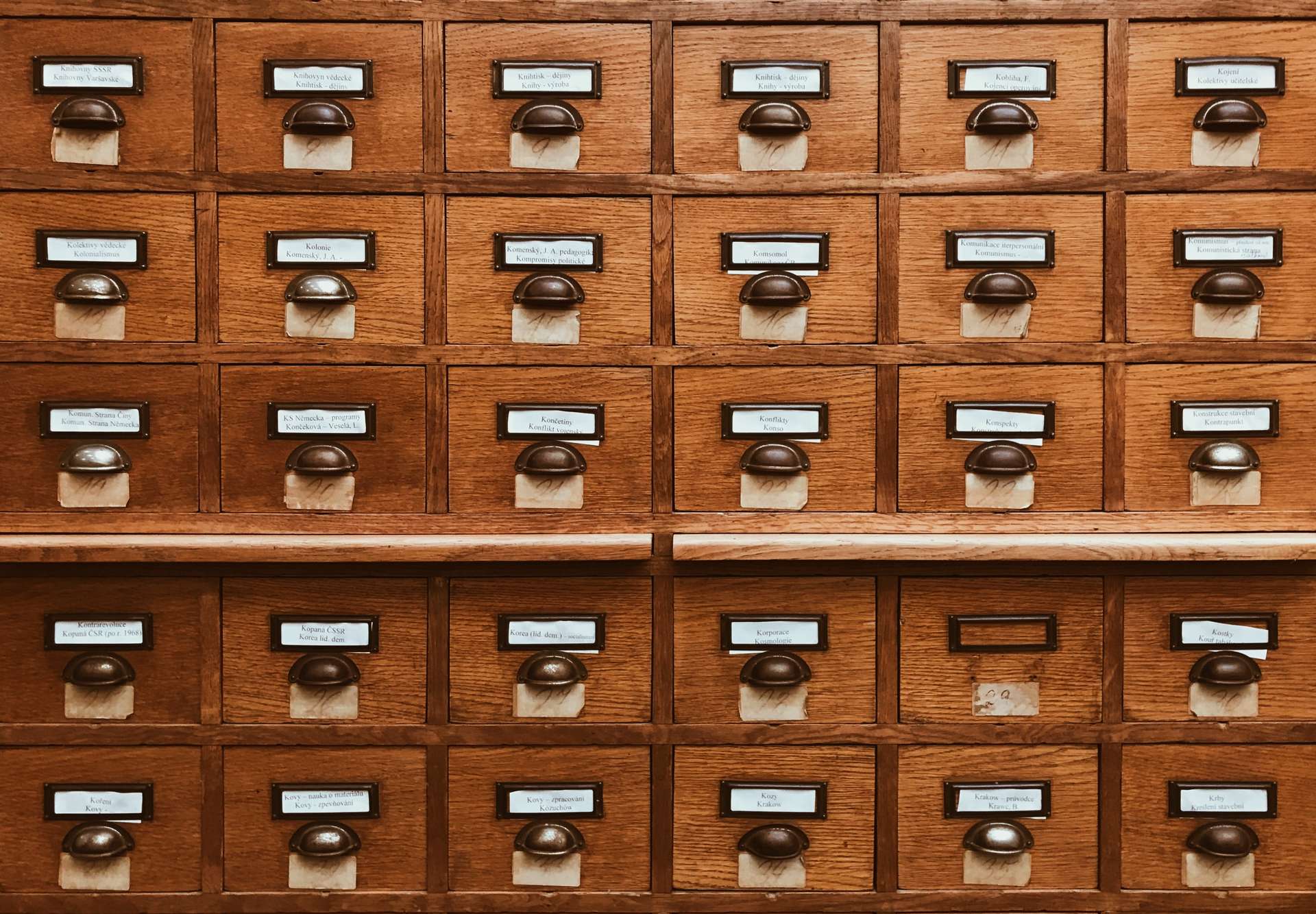 A wall of small wooden drawers