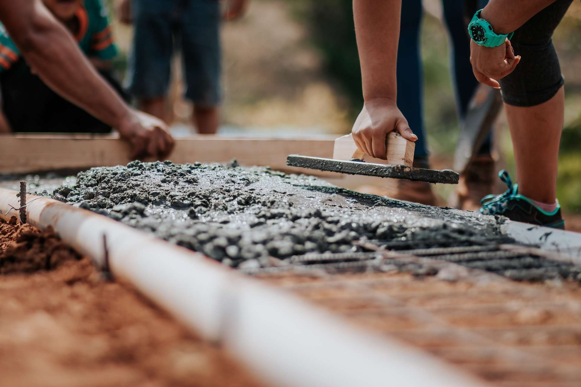 some people smoothing a concrete floor